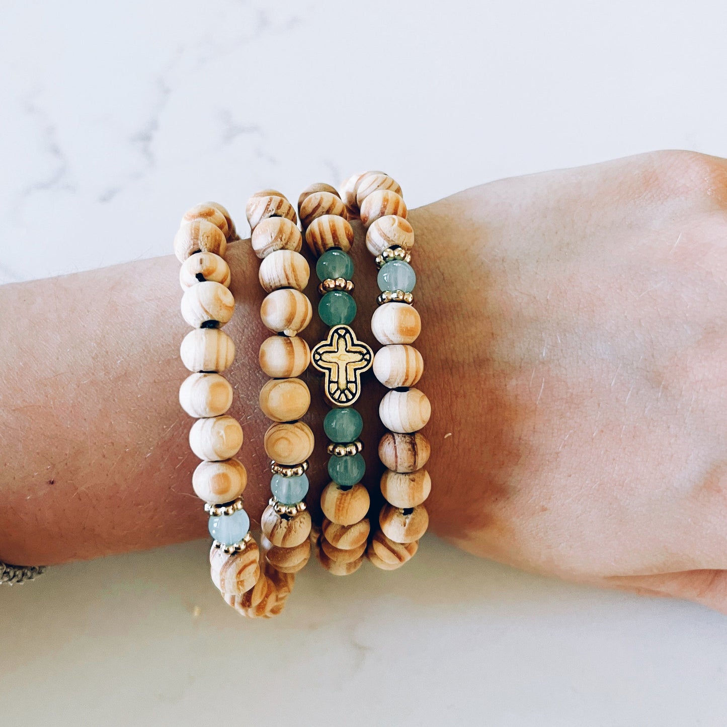 Stack of beaded bracelets on a wrist against a light background