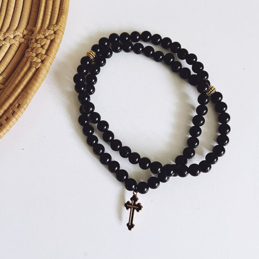 Pulsera de oración de ébano de 75 cuentas con separadores dorados y cruz esmaltada en negro.