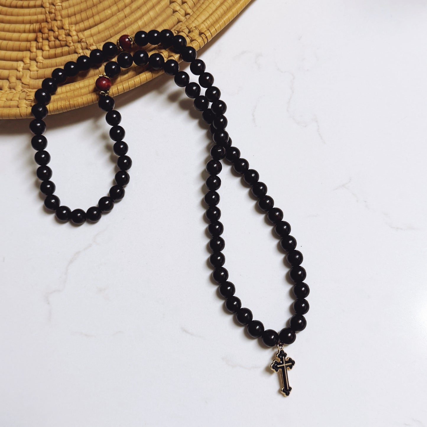 Pulsera de oración de ébano de 75 cuentas con separadores dorados y cruz esmaltada en negro.