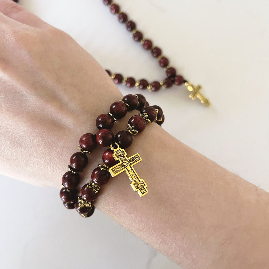 Pulsera de oración de ébano de 75 cuentas con separadores dorados y cruz esmaltada en negro.