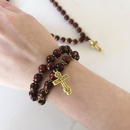 Pulsera de oración de ébano de 75 cuentas con separadores dorados y cruz esmaltada en negro.