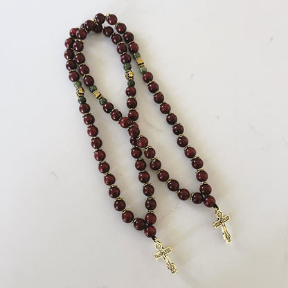 Pulsera de oración de ébano de 75 cuentas con separadores dorados y cruz esmaltada en negro.