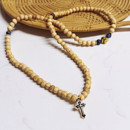 Wooden beaded necklace with a cross pendant on a white surface